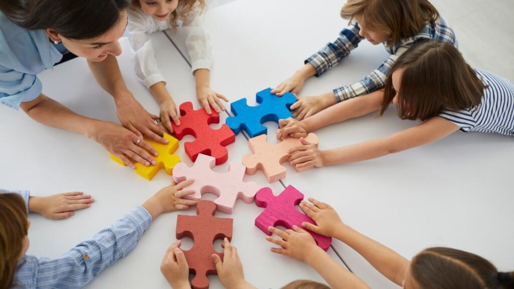 Hands working together to piece together a colorful puzzle, representing the collaborative effort between schools and parents to support and build stronger students